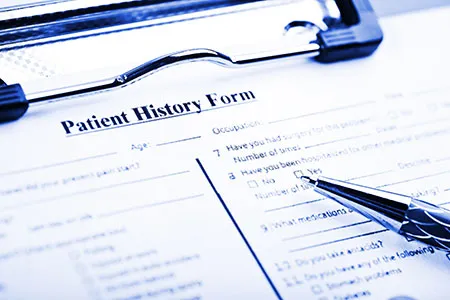 clipboard with patient history form on it